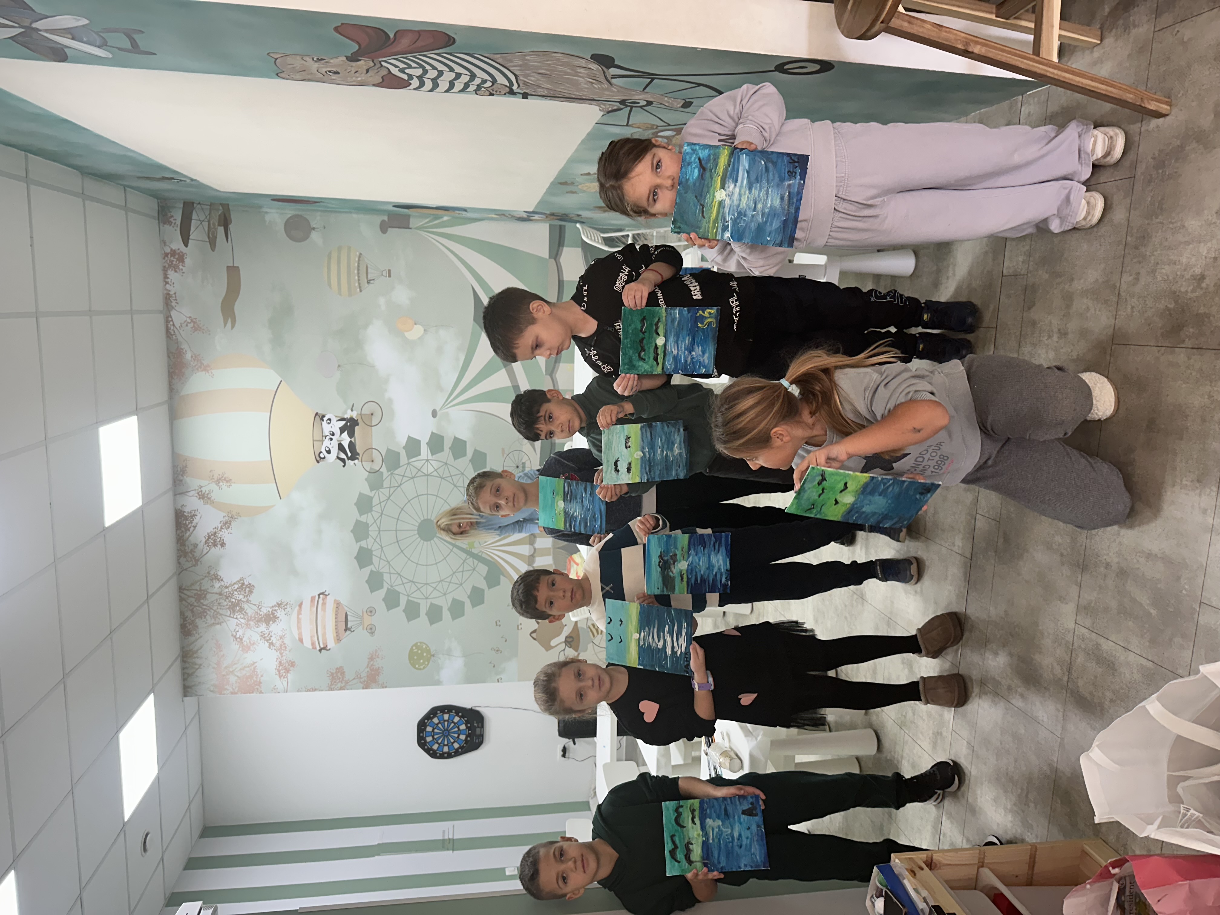 Children showing their finished seascape paintings