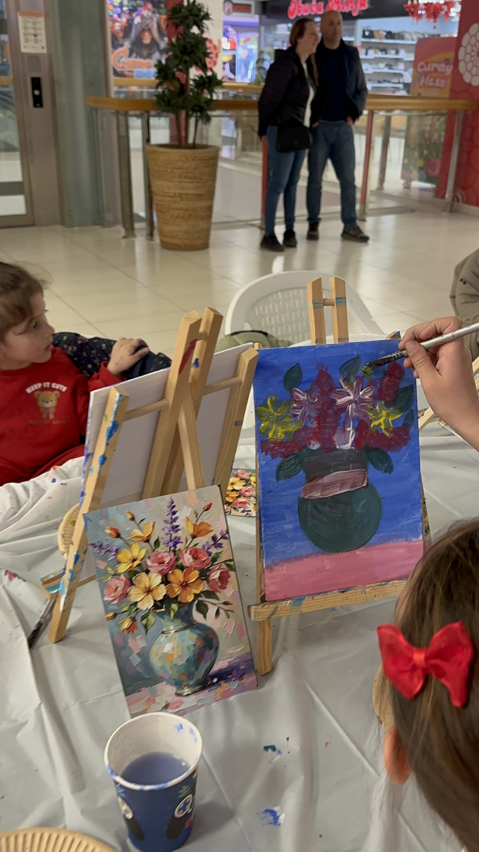 Easels arranged for a workshop with reference paintings and student work