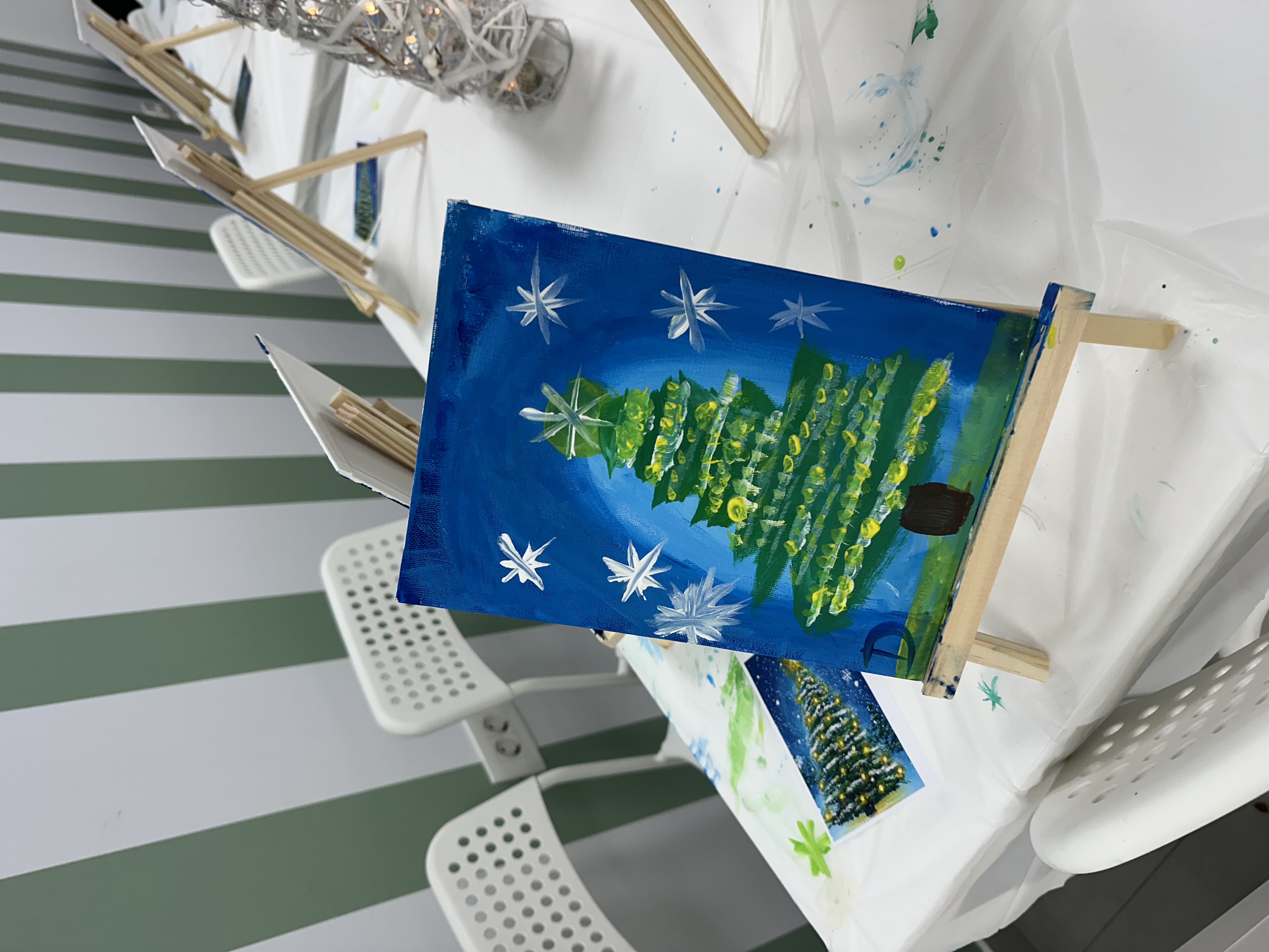 Christmas tree painting workshop — a finished canvas on a small easel